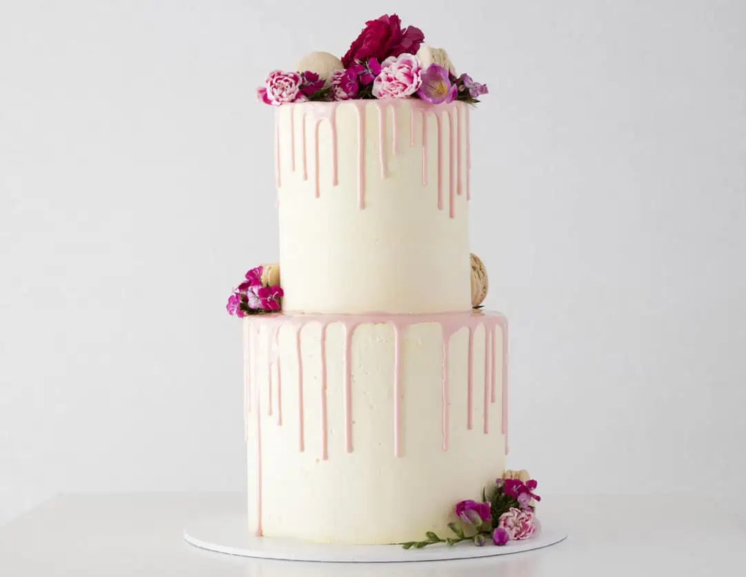 two tier wedding cake with creamy drips down on the sides of both layers