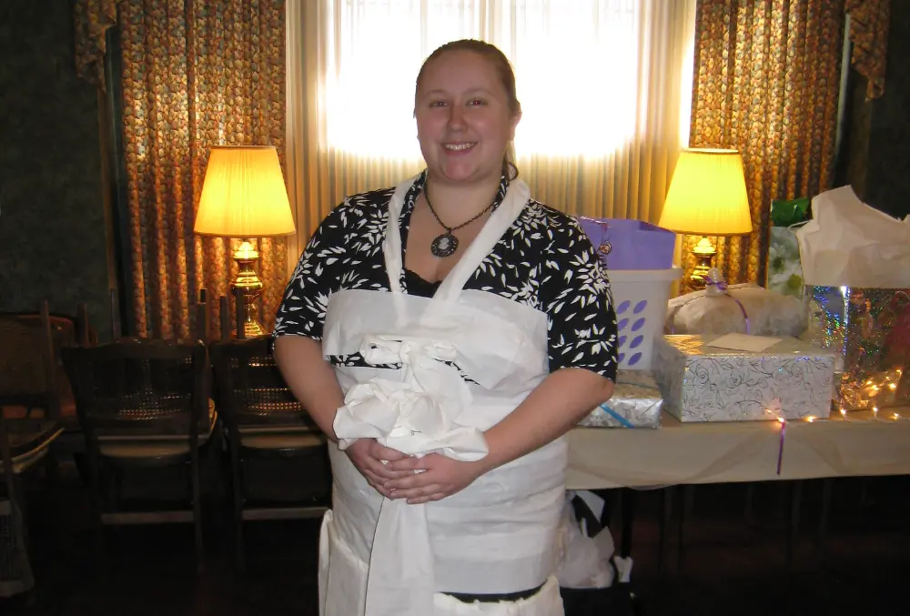 A lady wrapped up in toilet paper at a bridal shower